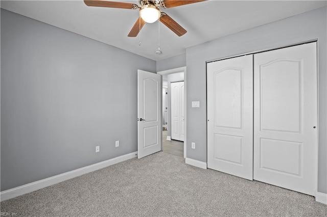 unfurnished bedroom with light carpet, a ceiling fan, baseboards, and a closet