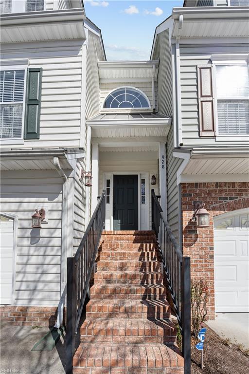 entrance to property featuring a garage and brick siding