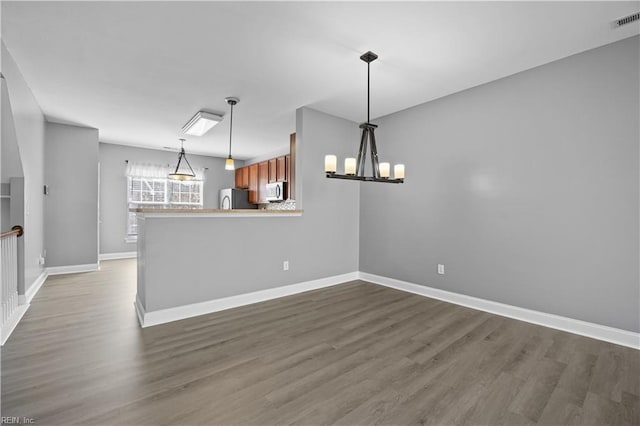 interior space featuring visible vents, baseboards, and dark wood finished floors