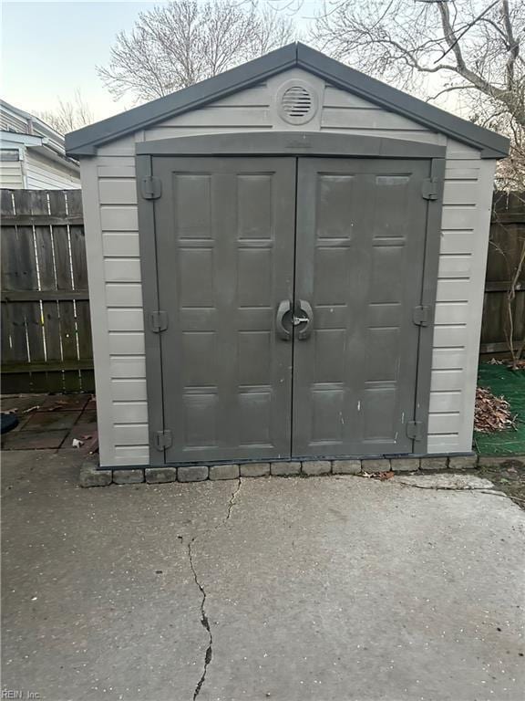 view of shed featuring fence