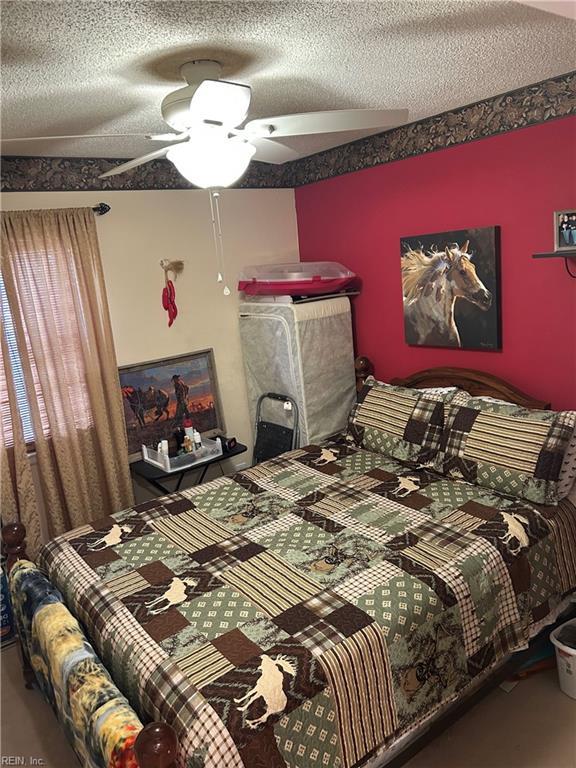 bedroom featuring ceiling fan and a textured ceiling