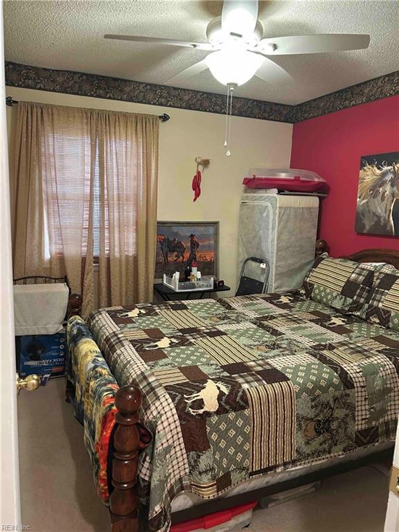 bedroom featuring a textured ceiling and a ceiling fan