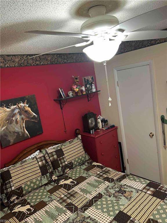 bedroom featuring ceiling fan and a textured ceiling