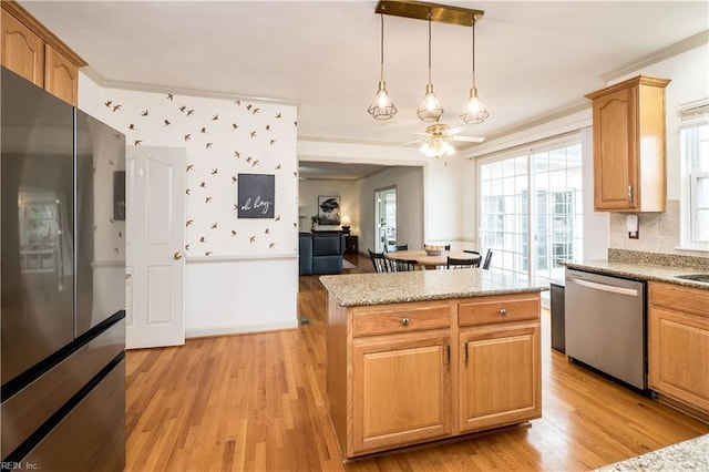 kitchen featuring appliances with stainless steel finishes, light wood-style floors, and crown molding