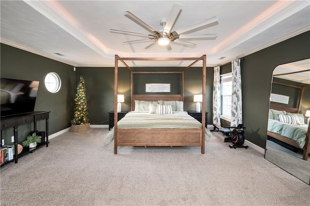 carpeted bedroom featuring a raised ceiling, crown molding, and baseboards