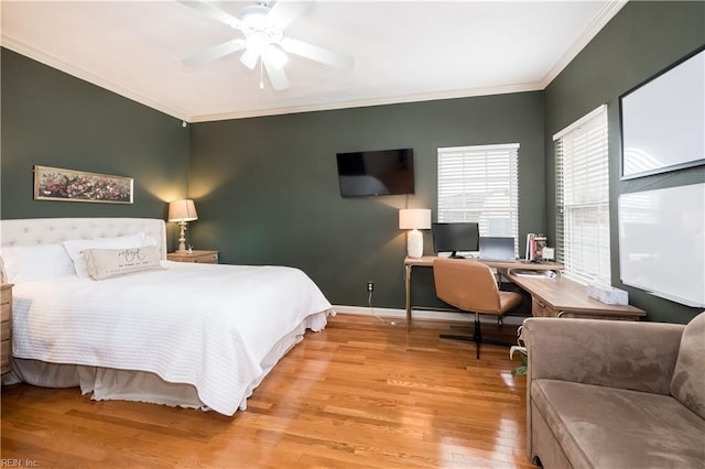 bedroom with a ceiling fan, crown molding, baseboards, and wood finished floors