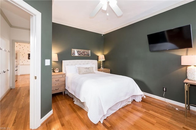 bedroom featuring crown molding, baseboards, ceiling fan, and wood finished floors