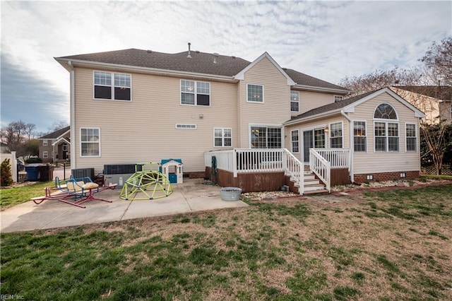 rear view of house featuring a patio area, a lawn, and a wooden deck