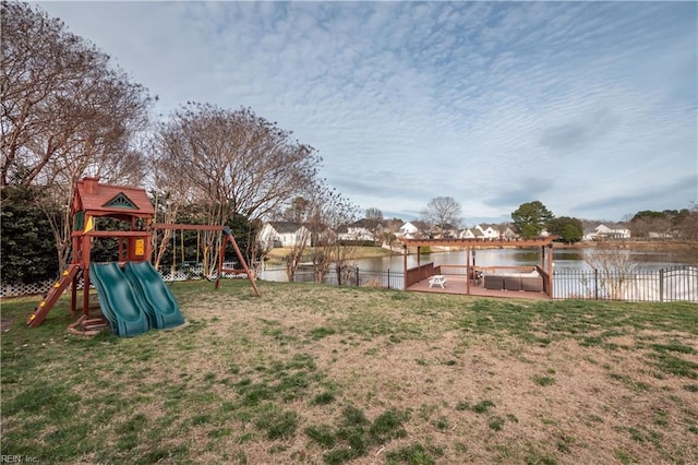 view of yard featuring a water view, fence, and a playground