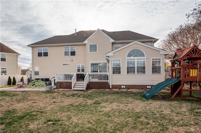 rear view of property featuring a playground, fence, crawl space, a lawn, and a patio area