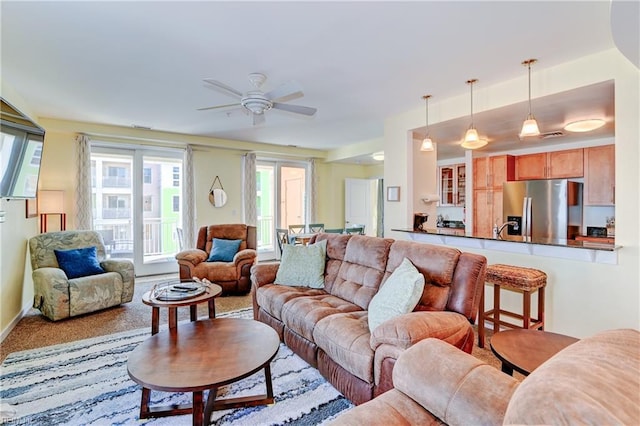 carpeted living room featuring ceiling fan