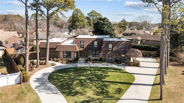 view of front of home featuring a residential view, fence, and a front yard