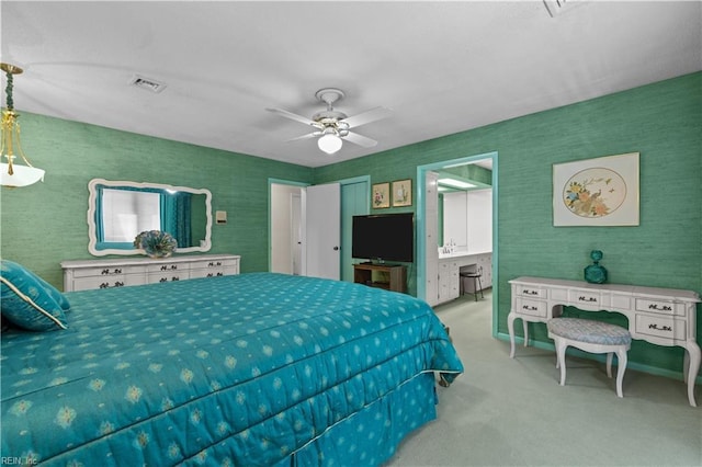 carpeted bedroom featuring visible vents, ceiling fan, ensuite bath, and wallpapered walls