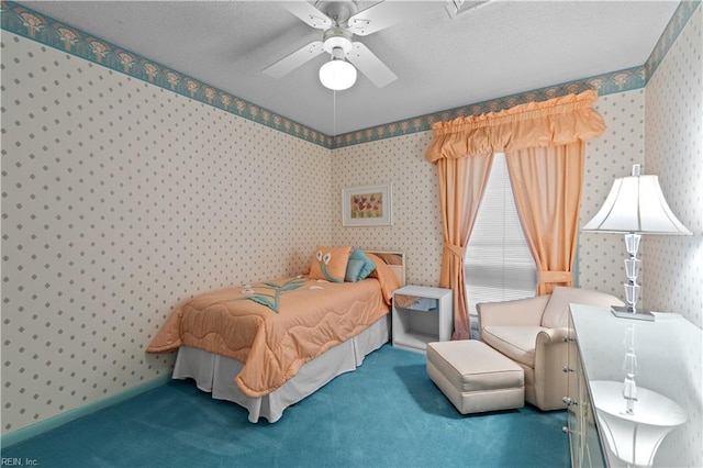 carpeted bedroom featuring wallpapered walls, ceiling fan, baseboards, and a textured ceiling