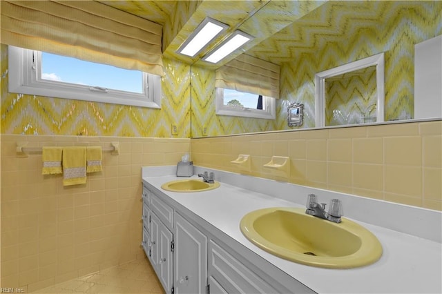 bathroom with a wealth of natural light, a sink, and wallpapered walls