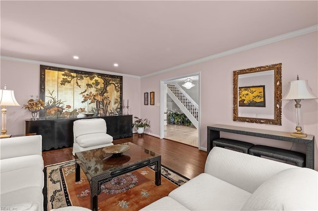 living area with stairs, crown molding, and wood finished floors