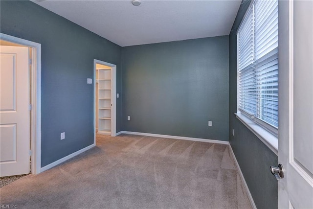 unfurnished room with light carpet and baseboards