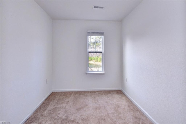 unfurnished room featuring baseboards, visible vents, and light colored carpet