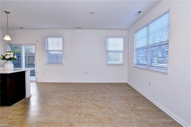 unfurnished room with light wood-type flooring, baseboards, and visible vents