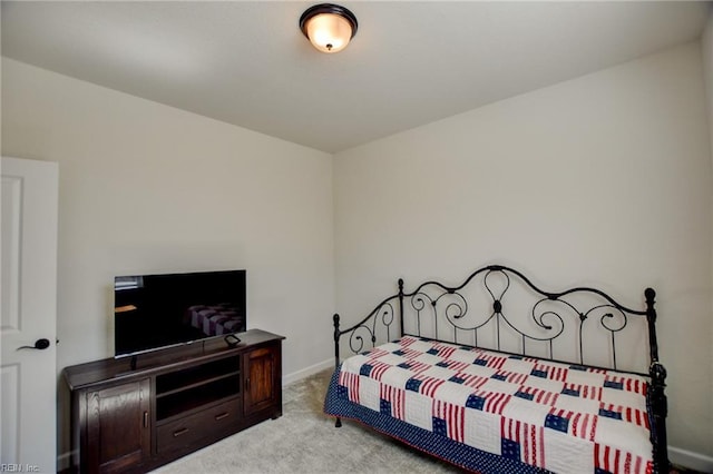 bedroom with light colored carpet and baseboards