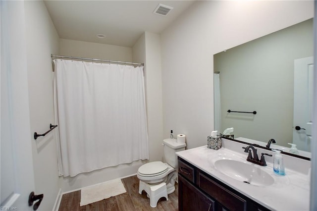 full bathroom with visible vents, toilet, shower / bath combo, vanity, and wood finished floors