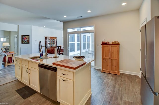 kitchen with dishwasher, wood finished floors, a sink, and recessed lighting