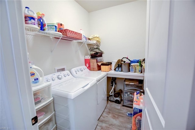 clothes washing area with laundry area, light wood finished floors, and washing machine and clothes dryer