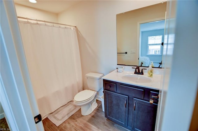 full bathroom featuring toilet, curtained shower, wood finished floors, and vanity