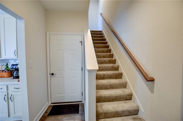 stairway with baseboards and wood finished floors