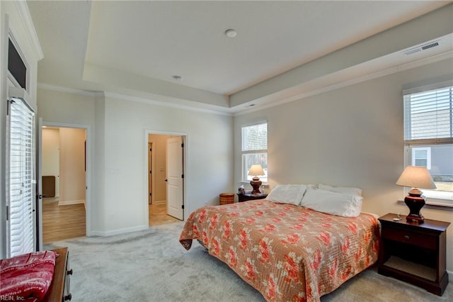 bedroom featuring carpet floors, a tray ceiling, crown molding, and baseboards