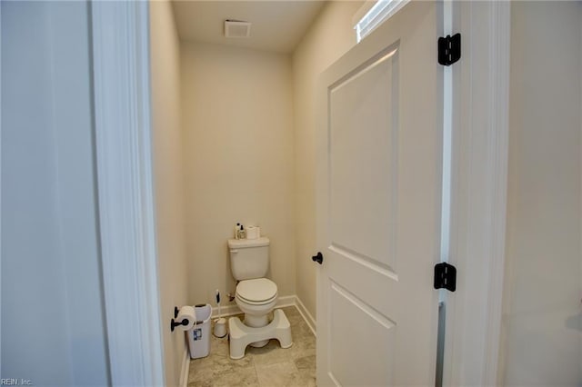 bathroom featuring baseboards, visible vents, toilet, and tile patterned floors