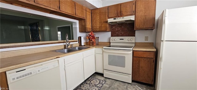 kitchen featuring white appliances, white cabinets, light countertops, under cabinet range hood, and a sink