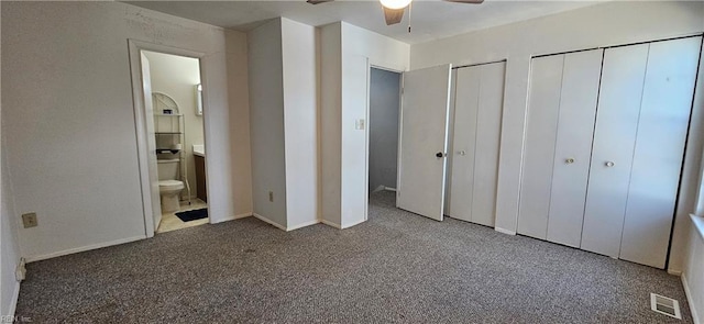 unfurnished bedroom featuring ensuite bathroom, two closets, carpet flooring, and visible vents