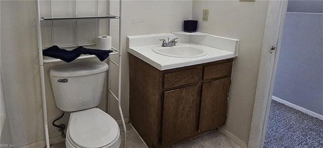 half bathroom featuring toilet, vanity, and baseboards