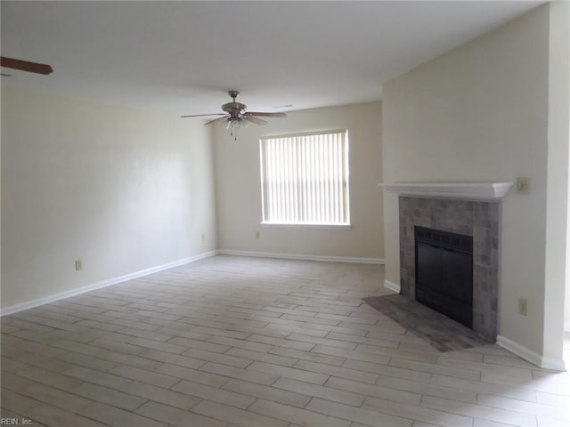 unfurnished living room with a ceiling fan, a fireplace, and baseboards