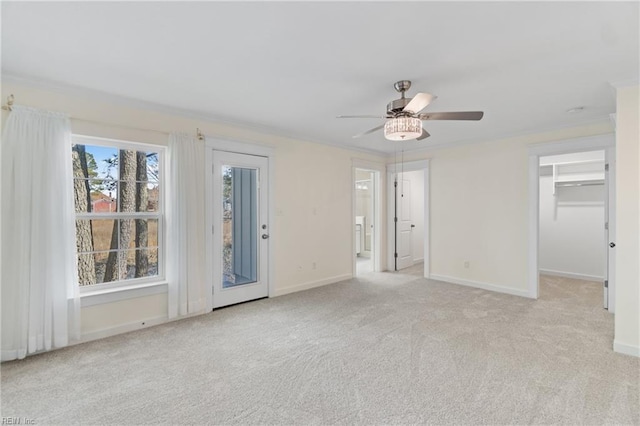 spare room featuring a ceiling fan, light colored carpet, and baseboards