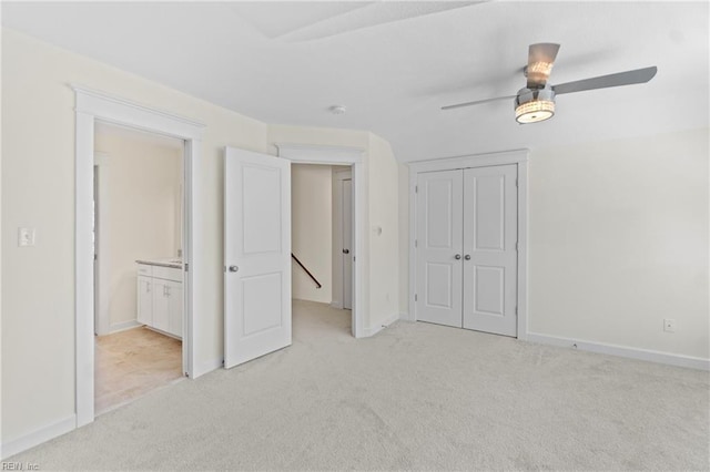 unfurnished bedroom with a ceiling fan, a closet, light colored carpet, and baseboards