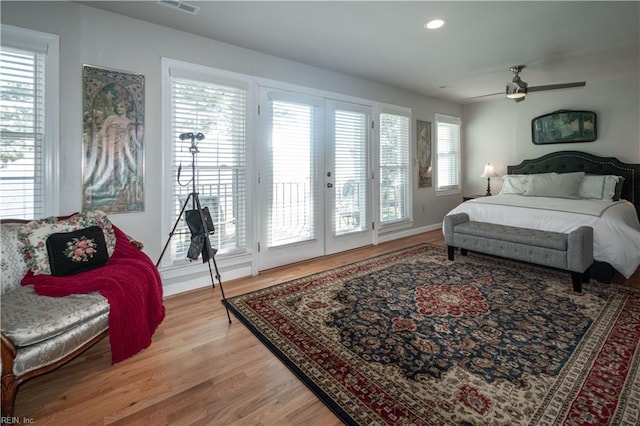 bedroom featuring access to exterior, light wood-type flooring, multiple windows, and recessed lighting