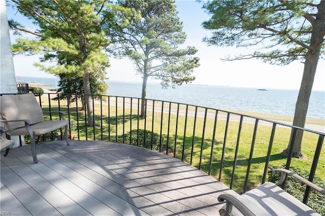 wooden terrace featuring a lawn and a water view