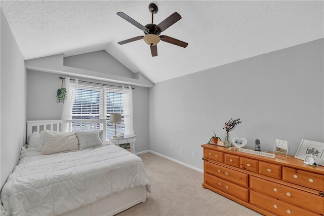 bedroom with light colored carpet, a ceiling fan, vaulted ceiling, a textured ceiling, and baseboards