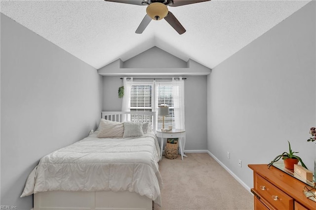 bedroom with a ceiling fan, light carpet, vaulted ceiling, a textured ceiling, and baseboards