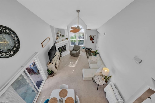 living room with a fireplace with flush hearth, light colored carpet, vaulted ceiling, and baseboards