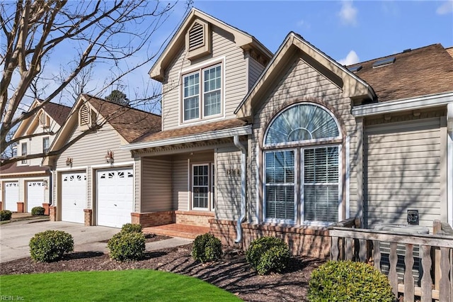 view of front of house featuring a garage, concrete driveway, brick siding, and roof with shingles