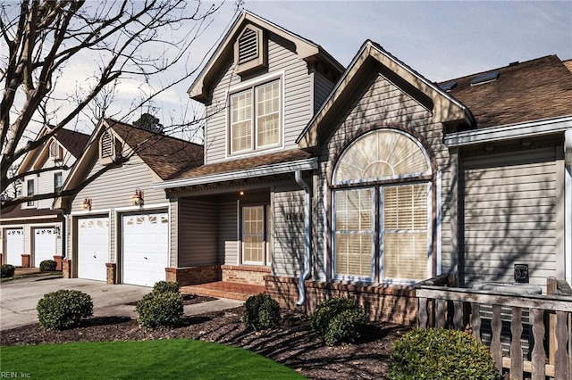 view of front of property featuring a shingled roof, brick siding, driveway, and an attached garage