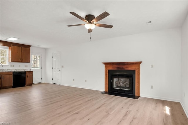 unfurnished living room featuring visible vents, a fireplace with flush hearth, light wood-style flooring, and baseboards