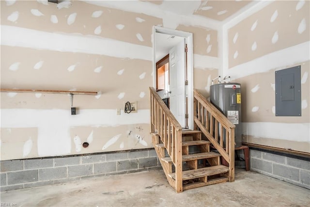 basement featuring water heater, electric panel, and concrete block wall