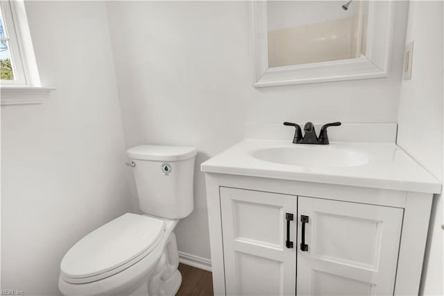 bathroom with baseboards, vanity, and toilet