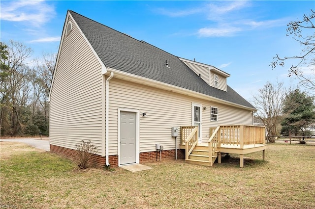 back of property with a shingled roof, a yard, and a deck