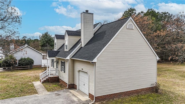 view of side of property with a shingled roof, a lawn, and a chimney