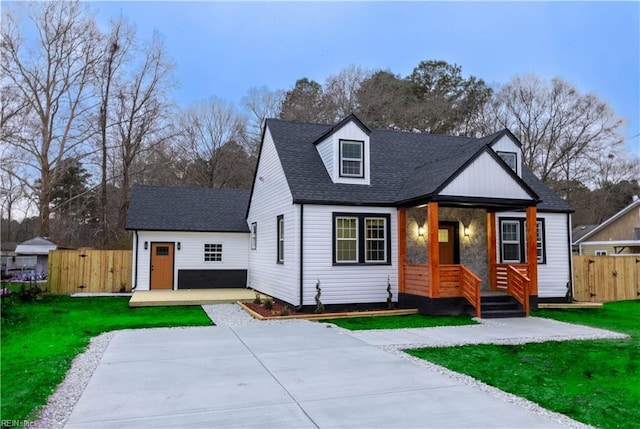 view of front of home featuring a front yard, roof with shingles, fence, and driveway